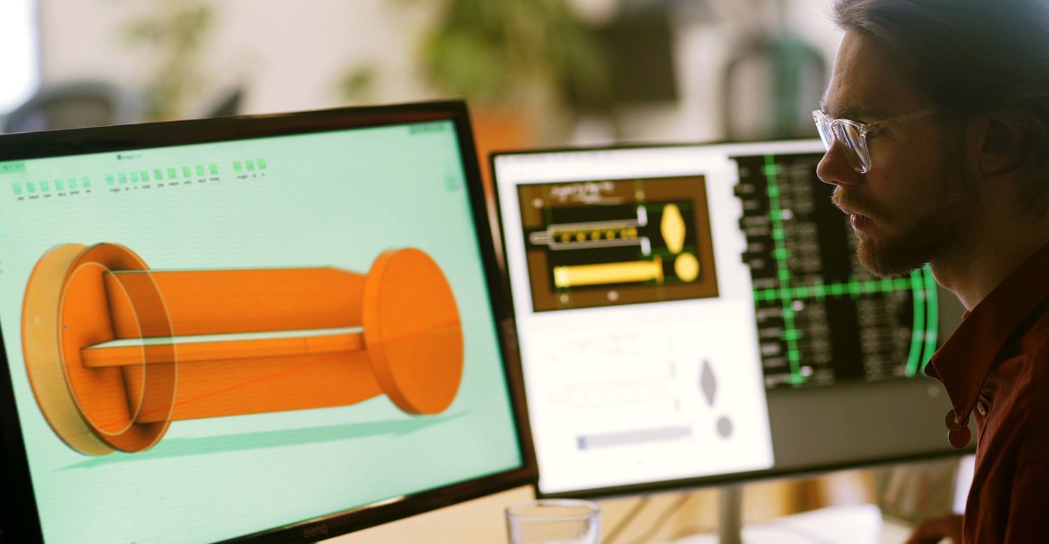 Man working on a 3D model in a dual-screen setup